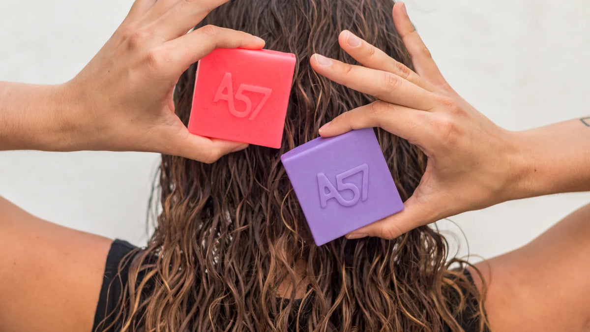 Shampoo y acondicionador A57 en las manos sobre cabello mojado